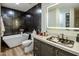 Bathroom featuring large, dark wall tiles, a modern tub, and a unique sink bowl on a marble vanity at 5104 N 32Nd St # 105, Phoenix, AZ 85018