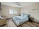 Bright bedroom with wood-look floors, modern ceiling fan, a shuttered window, and simple, matching floating shelves at 5104 N 32Nd St # 105, Phoenix, AZ 85018