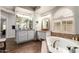 Luxurious bathroom features dual sinks, granite counters, and large soaking tub with wood-look flooring at 518 S Bay Shore Blvd, Gilbert, AZ 85233