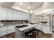 Spacious kitchen boasts white cabinets, granite countertops, a center island with seating, and modern appliances at 518 S Bay Shore Blvd, Gilbert, AZ 85233