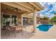 Inviting covered patio featuring a ceiling fan, outdoor seating and refreshing pool at 518 S Bay Shore Blvd, Gilbert, AZ 85233