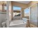 This bathroom features a soaking tub, tile surround, walk-in shower, and window with backyard view at 5813 E Ashler Hills Dr, Cave Creek, AZ 85331