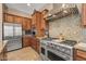 This kitchen features stainless appliances, granite countertops, custom cabinets, and a professional range with custom vent hood at 5813 E Ashler Hills Dr, Cave Creek, AZ 85331
