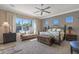 This spacious primary bedroom features a ceiling fan, ample natural light from large windows, and neutral decor at 5813 E Ashler Hills Dr, Cave Creek, AZ 85331