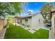 Backyard with synthetic grass, a paver patio and pergola with string lights at twilight at 6335 E Brown Rd # 1084, Mesa, AZ 85205