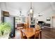 Cozy dining area with wooden table and chairs, open to the kitchen and living room with wood floors at 6335 E Brown Rd # 1084, Mesa, AZ 85205