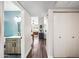 View of wood-look hallway that leads to kitchen with bathroom to the side featuring a stylish sink and blue accent wall at 6335 E Brown Rd # 1084, Mesa, AZ 85205