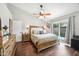 Bright main bedroom featuring a ceiling fan, ensuite bathroom, and sliding glass door to the backyard at 6335 E Brown Rd # 1084, Mesa, AZ 85205