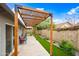 Backyard features a pergola with string lights over a patio and artificial turf at 6335 E Brown Rd # 1084, Mesa, AZ 85205