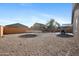 Expansive backyard with gravel, trampoline, patio seating, and a secure brick fence at 697 E Ruby Dr, Casa Grande, AZ 85122