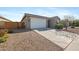 Angle view of home with large two car garage, desert landscaping and walkway to covered entry at 697 E Ruby Dr, Casa Grande, AZ 85122
