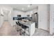 Bright kitchen features white cabinetry, stainless steel appliances, and a granite-topped island with seating at 697 E Ruby Dr, Casa Grande, AZ 85122