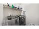 Well-equipped laundry room with modern washer and dryer units and practical storage shelves at 697 E Ruby Dr, Casa Grande, AZ 85122