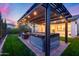 A backyard features a pergola-covered patio, hot tub, and outdoor seating with manicured lawn at 6983 W Andrea Dr, Peoria, AZ 85383