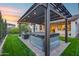 A backyard features a pergola-covered patio with string lights, hot tub, and outdoor seating on a brick patio at 6983 W Andrea Dr, Peoria, AZ 85383