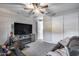 Spacious carpeted bedroom with ceiling fan, TV on cabinet with fireplace, and closet at 6983 W Andrea Dr, Peoria, AZ 85383