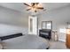 Minimalist bedroom with grey bedding, dark dresser, and a view through the doorway at 6983 W Andrea Dr, Peoria, AZ 85383