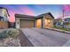 Exterior view of home with desert landscaping, brick driveway, two-car garage, and charming front porch at 6983 W Andrea Dr, Peoria, AZ 85383