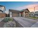 Inviting home exterior with a brick driveway, desert landscaping, and a charming covered front porch at 6983 W Andrea Dr, Peoria, AZ 85383