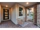 Inviting front porch with seating area, stylish brickwork, and an attractive entryway door at 6983 W Andrea Dr, Peoria, AZ 85383
