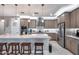 Modern kitchen with granite island, stainless appliances, pendant lights, and stylish bar stool seating at 6983 W Andrea Dr, Peoria, AZ 85383