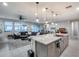 Open-concept kitchen with granite island, stainless sink, and view into the dining and living areas at 6983 W Andrea Dr, Peoria, AZ 85383