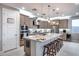 Modern kitchen with stainless steel appliances, granite countertops, island with seating, and stylish pendant lighting at 6983 W Andrea Dr, Peoria, AZ 85383