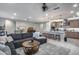 Open concept living room with a large grey sectional sofa, kitchen, and dining area under recessed lighting at 6983 W Andrea Dr, Peoria, AZ 85383