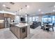 Open-concept kitchen, dining, and living area with tile flooring, large windows, and stylish furnishings at 6983 W Andrea Dr, Peoria, AZ 85383