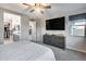 Primary bedroom features a large TV, a window, closet access, and access to the ensuite bathroom at 6983 W Andrea Dr, Peoria, AZ 85383
