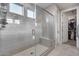 Tiled walk-in shower with glass enclosure, a bench, and a view of the walk-in closet at 6983 W Andrea Dr, Peoria, AZ 85383