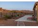 Desert backyard featuring covered patio, pavers and mountain views beyond at 7659 S 164Th Ln, Goodyear, AZ 85338
