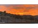 Dramatic desert landscape with a colorful sunset sky over a fenced-in yard at 7659 S 164Th Ln, Goodyear, AZ 85338