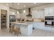 Bright kitchen featuring an island, white cabinets, granite counters, and stainless steel appliances at 7659 S 164Th Ln, Goodyear, AZ 85338