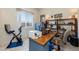 Bright and airy home office featuring a large window, desk space, and exercise equipment at 7659 S 164Th Ln, Goodyear, AZ 85338