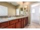 Bathroom with double sinks, granite countertops, wood cabinets and walk-in shower at 8149 N 13Th Pl, Phoenix, AZ 85020