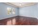 Bedroom with two windows, wood floors, ceiling fan, and light blue walls at 8149 N 13Th Pl, Phoenix, AZ 85020