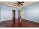 Light blue bedroom featuring hardwood floors, white trim, ceiling fan, and view into closet and doorway at 8149 N 13Th Pl, Phoenix, AZ 85020