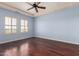 This bedroom features blue walls, brown wood floors, plantation shutters, and a ceiling fan at 8149 N 13Th Pl, Phoenix, AZ 85020