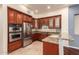 Modern kitchen with stainless steel appliances, granite counters, and wood cabinetry with decorative glass at 8149 N 13Th Pl, Phoenix, AZ 85020