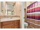 Neutral bathroom featuring a wood vanity, tile backsplash, and a shower-tub combo with a patterned curtain at 815 W Juniper Ln, Litchfield Park, AZ 85340