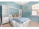 A vibrant bedroom with a blue accent wall, featuring a built-in bed frame and storage, complemented by stylish decor at 815 W Juniper Ln, Litchfield Park, AZ 85340