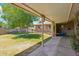 Spacious backyard featuring a covered patio, mature trees, a well-maintained lawn, and a charming water fountain at 8202 E Coolidge St, Scottsdale, AZ 85251