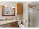 Well-lit bathroom features granite counters, wood cabinets, and a glass enclosed shower stall at 8202 E Coolidge St, Scottsdale, AZ 85251