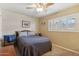 Bedroom features a queen bed with cozy gray bedding, ceiling fan, neutral carpet, and a window with white shutters at 8202 E Coolidge St, Scottsdale, AZ 85251