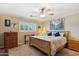 Bright bedroom with neutral walls, ceiling fan, and window with white shutters, creating a serene and comfortable space at 8202 E Coolidge St, Scottsdale, AZ 85251