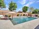 Beautiful backyard features a refreshing pool, a lounge chair, mature trees, and a tranquil waterfall feature at 8654 W Melinda Ln, Peoria, AZ 85382