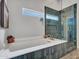Modern bathroom featuring a soaking tub with gold finishes, along with a glass walk in shower at 8654 W Melinda Ln, Peoria, AZ 85382