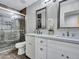 Modern bathroom with a double sink vanity, granite countertop, decorative mirrors and updated shower with glass door at 8654 W Melinda Ln, Peoria, AZ 85382