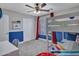 Comfortable bedroom with bunk beds, a ceiling fan, shutters, and blue accent wall for a fun design at 8654 W Melinda Ln, Peoria, AZ 85382